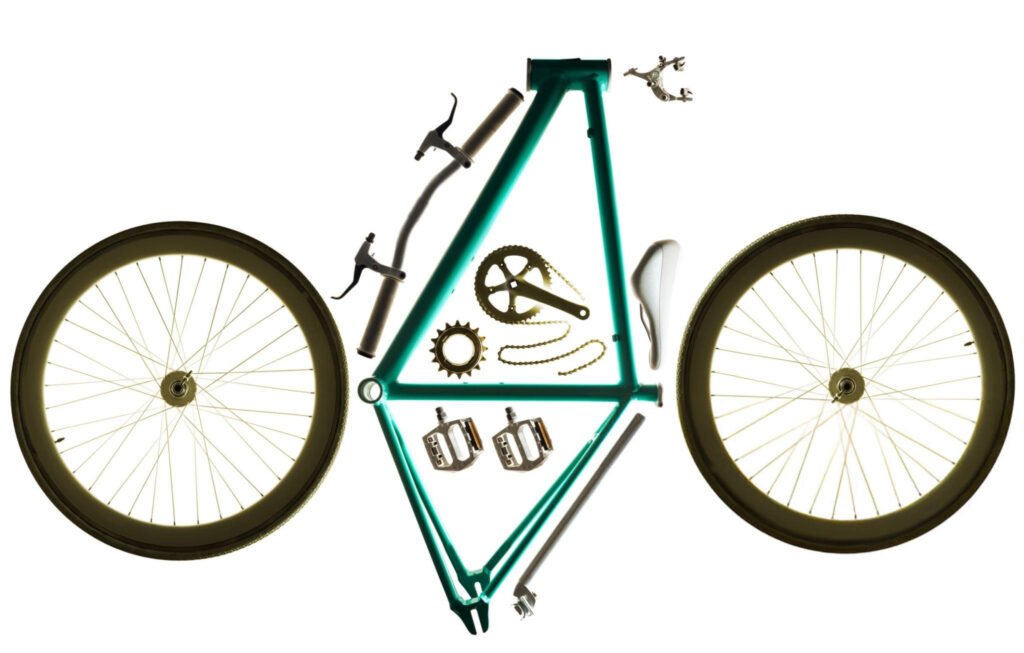 Partes de una bicicleta organizadas: cuadro, ruedas, pedales y cadena, mostrando los componentes esenciales para entender cómo escoger la bicicleta adecuada según su uso.