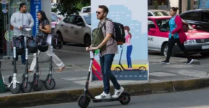Usuario de scooter eléctrico en la CDMX, con más unidades de renta estacionadas en la acera, dentro del nuevo marco de regulación de movilidad.