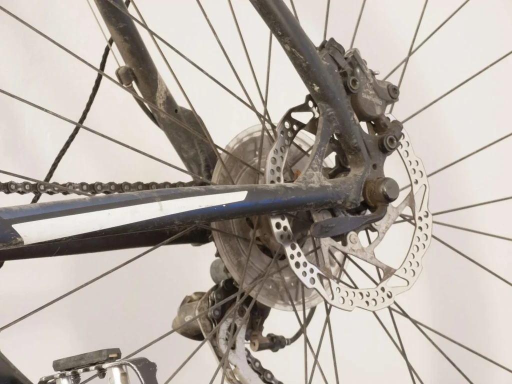 Detalle de frenos de bici desgastados y sucios que necesitan limpieza y mantenimiento.