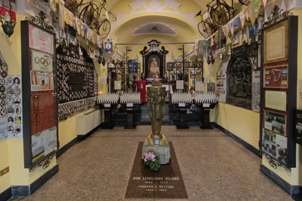 Interior del santuario ciclista del Ghisallo con ofrendas, fotografías y bicicletas conmemorativas.