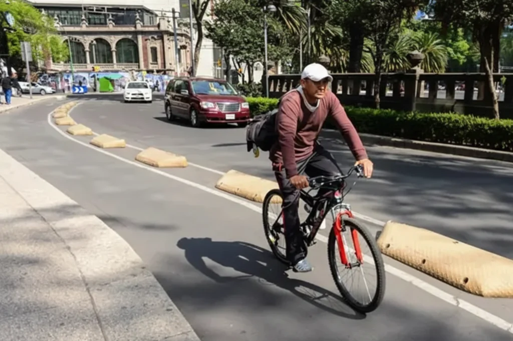 Ciclista avanzando por la infraestructura ciclista de Reforma, delimitada con los primeros dispositivos de confinamiento instalados.